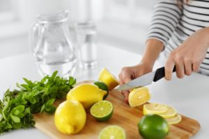 woman cutting lemons and limes